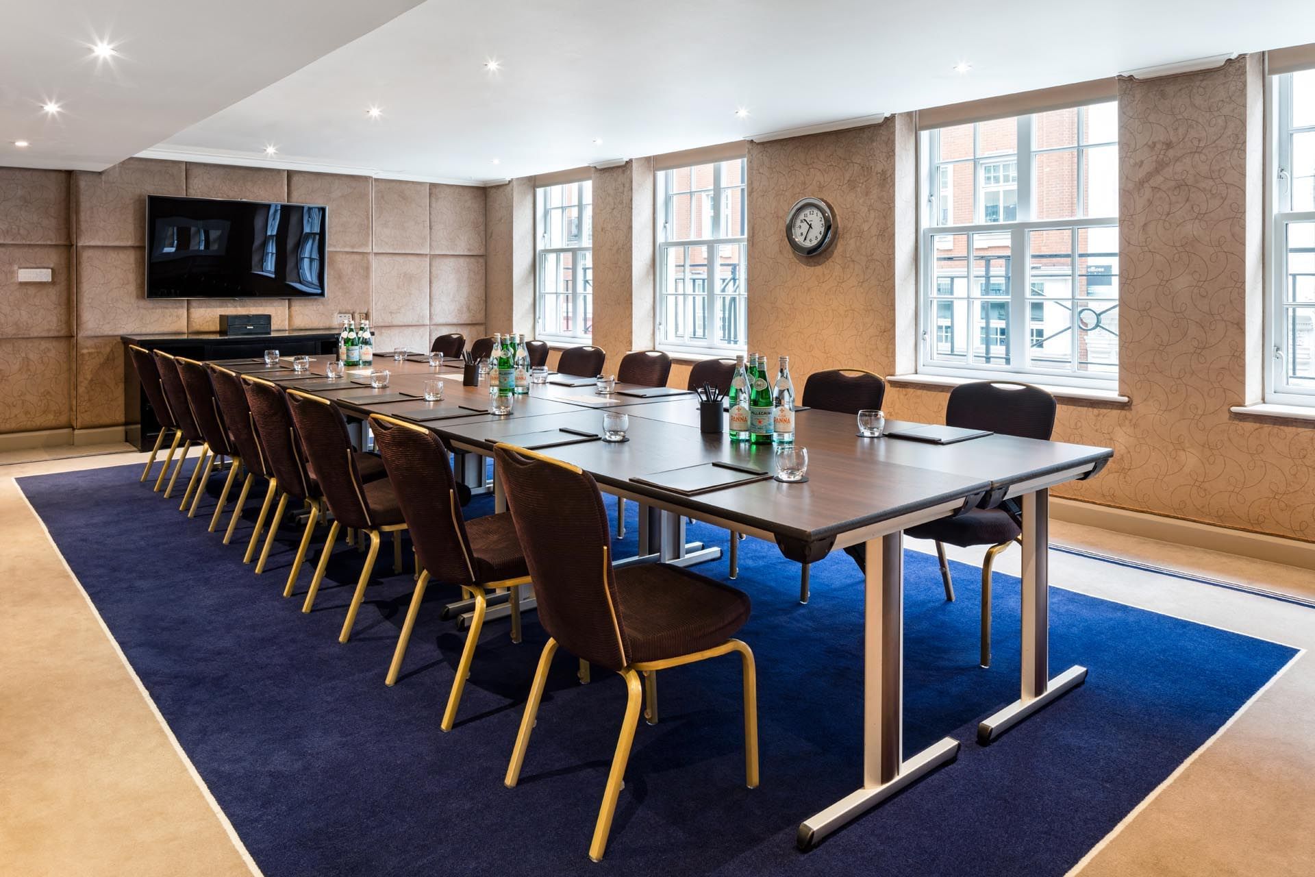 Boardroom table with TV arranged for small meetings in a private suite at The May Fair Hotel