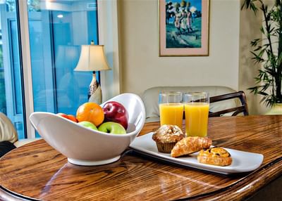 Breakfast pastries, a fruit bowl and fresh juice served on a table at Accra Hotels & Resorts