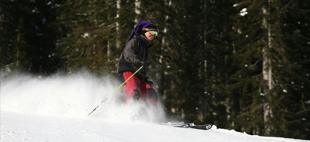 A skier smiles on a sunny day on a ski hill near Banff.