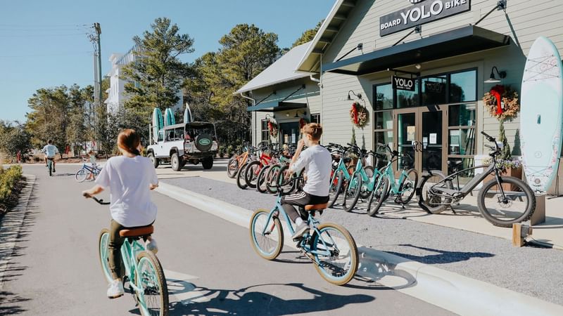 Family riding bikes in front of YOLO Board + Bike in Greenway Station