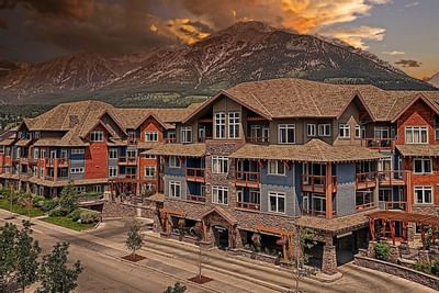 Blackstone Mountain Lodge with wood and stone exteriors, set against a dramatic sunset sky with mountain views