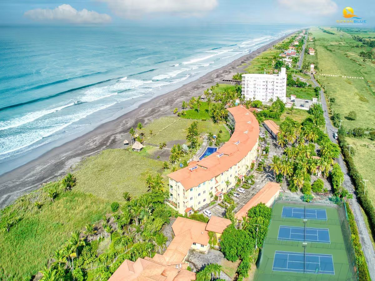 Aerial view of Las Brisas Del Mar Oceanfront Condominium surrounded by sea and greenery at Las Olas Beach Resort