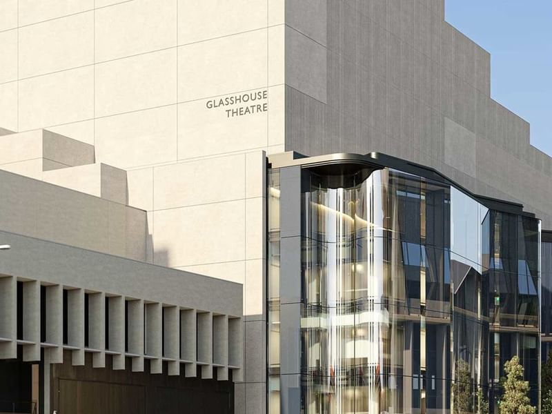 Modern glass and concrete facade of QPAC featuring the Glasshouse Theatre entrance under clear blue sky
