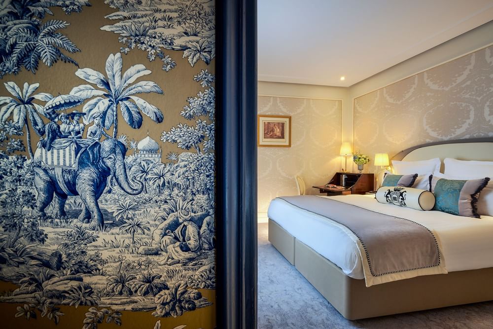 Elegant bedroom at Warwick Hotels and Resorts, featuring a large bed and intricate patterned wallpaper