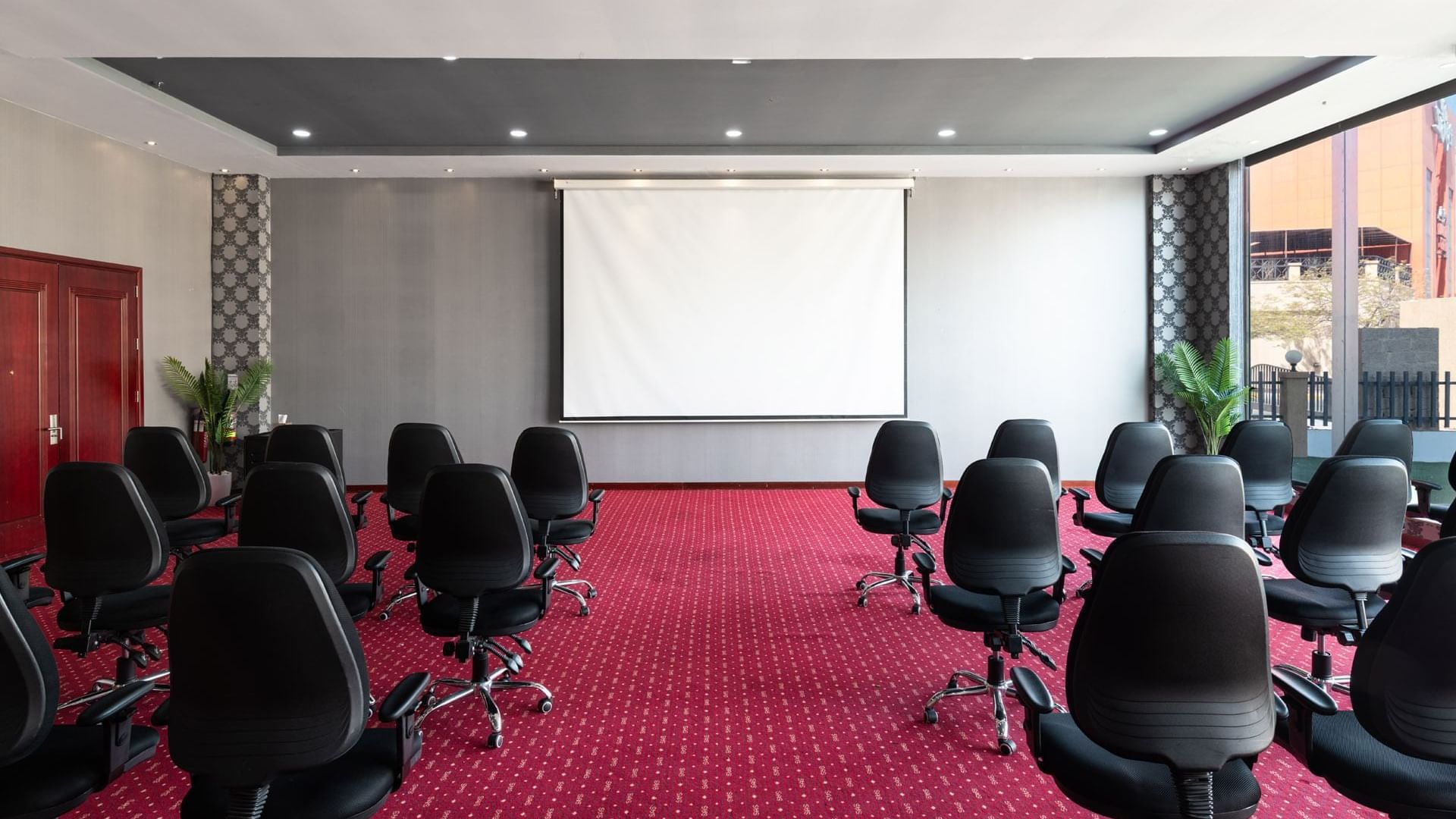 Amarige 1 conference room with chairs arranged in rows, featuring a projection screen, at Warwick Hotels and Resorts