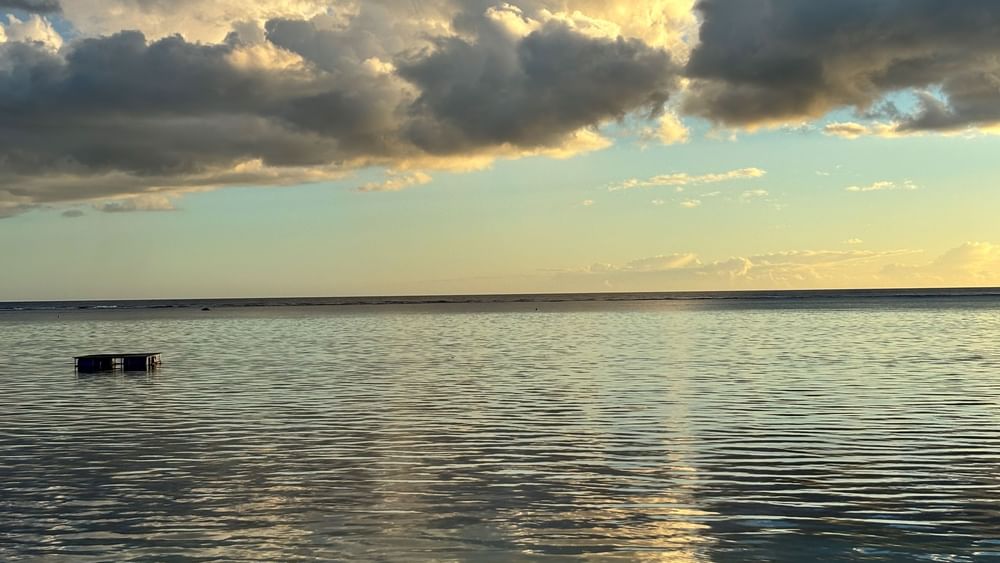 Calm ocean water with a distant horizon under a cloudy sky at Warwick Fiji Resort and Spa, Korolevu.