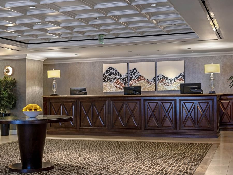 Long wood desk by lamps under a coffered ceiling near mountain art at Warwick Denver