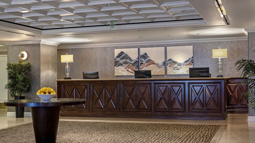 Long wood desk by lamps under a coffered ceiling near mountain art at Warwick Denver