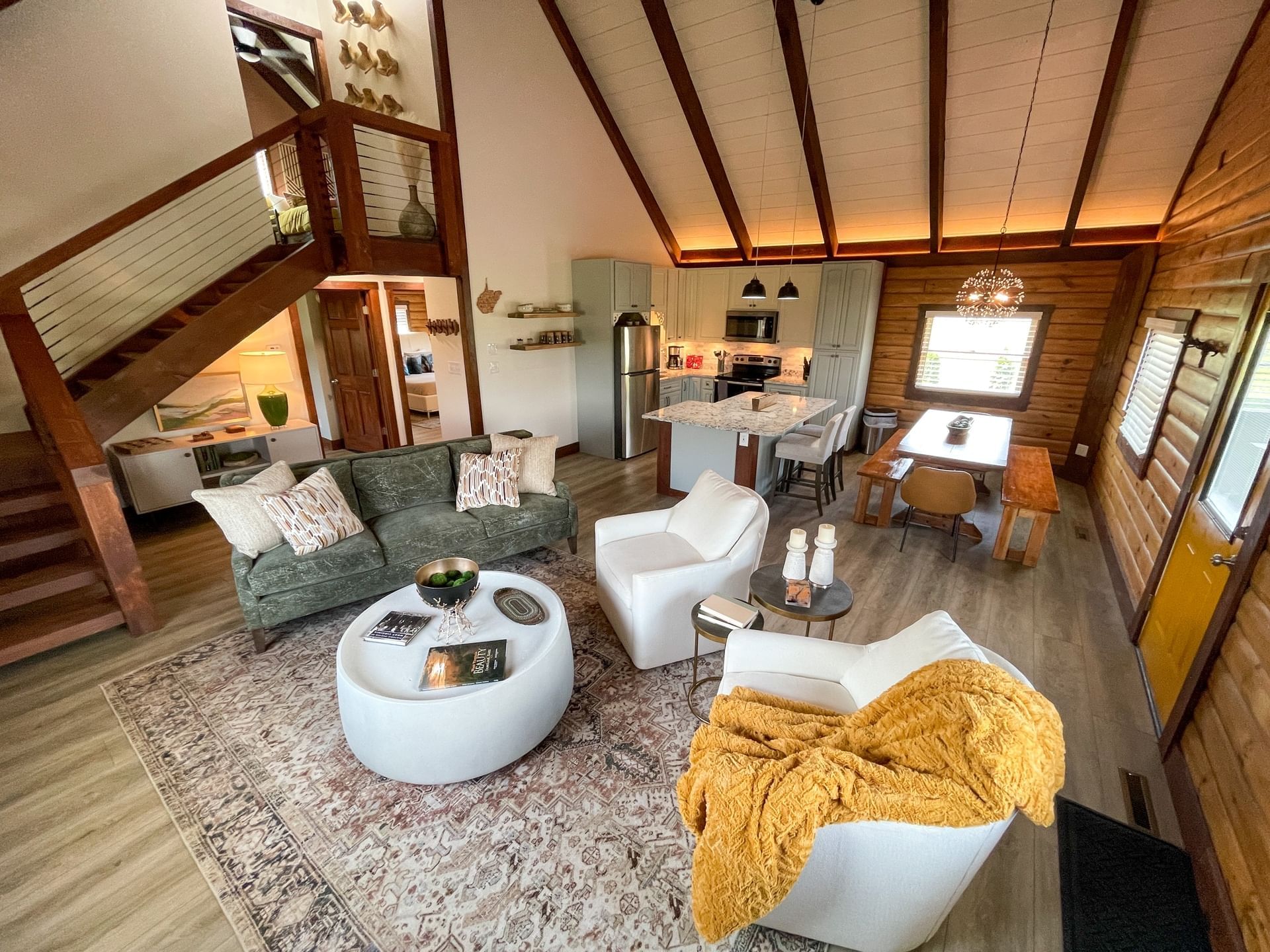 Living area in Barton House with comfy chairs, coffee table, kitchenette & dining table at The Inn at Canaan