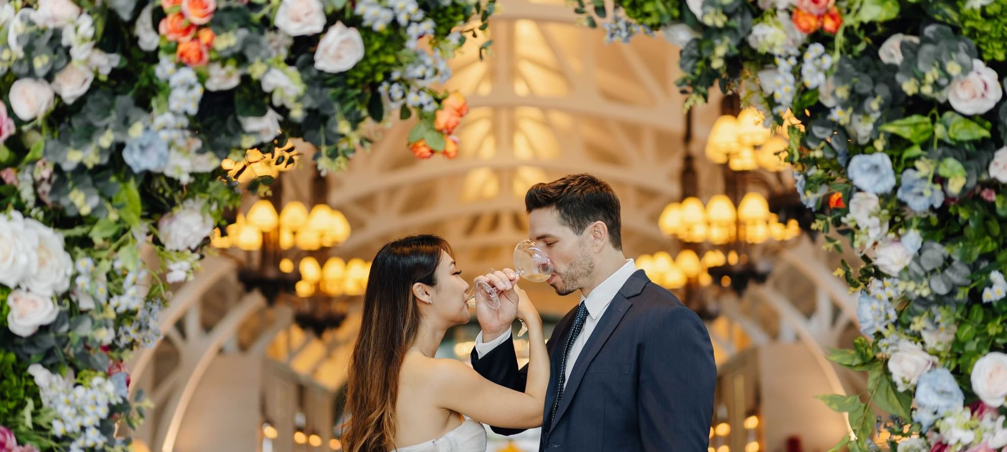 Couple in wedding attire drinking win in wedding hall at The Fullerton Bay Singapore