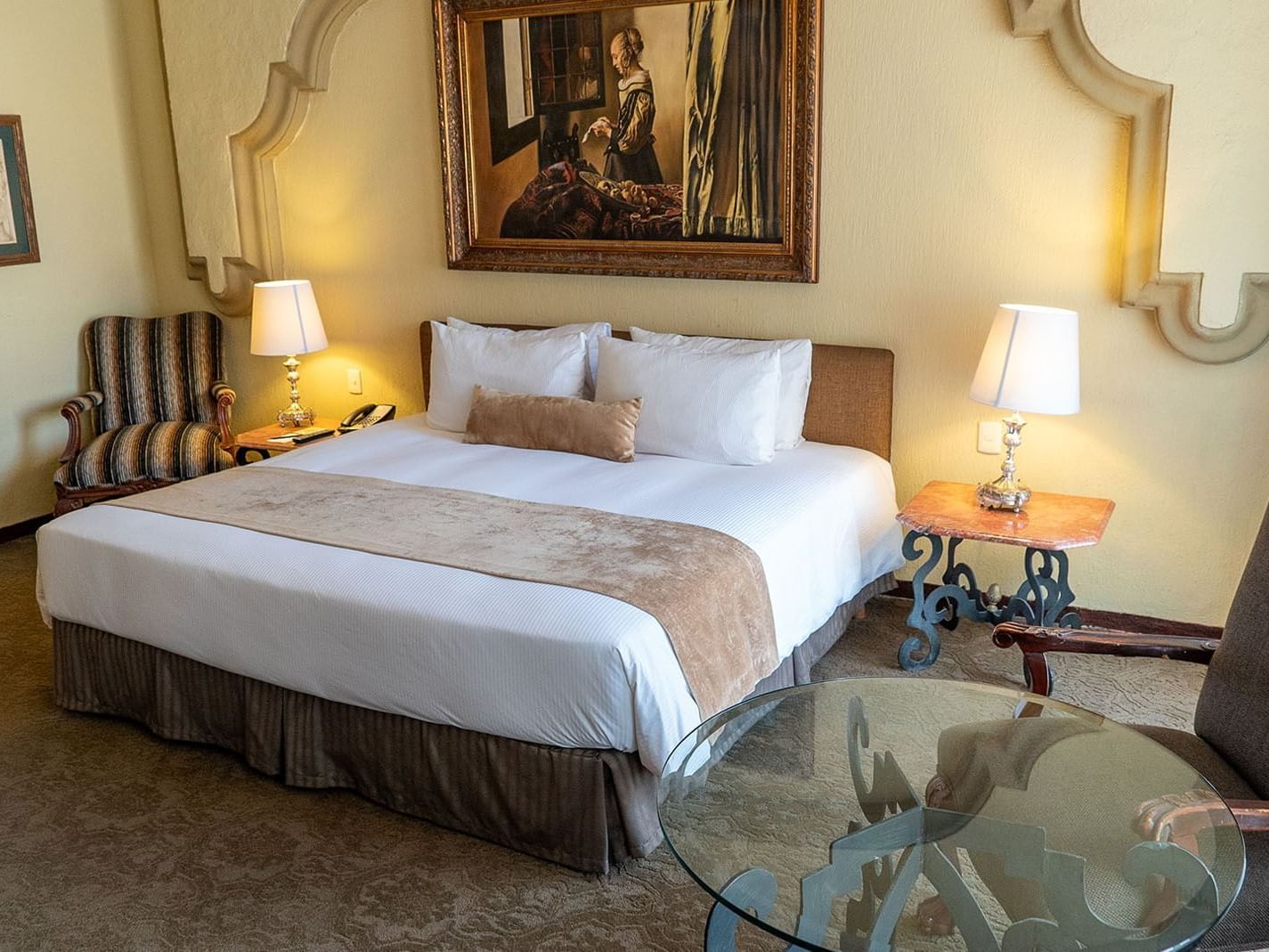 King Master Suite with a king bed, art piece, and ornate lamps at Quinta Real Aguascalientes