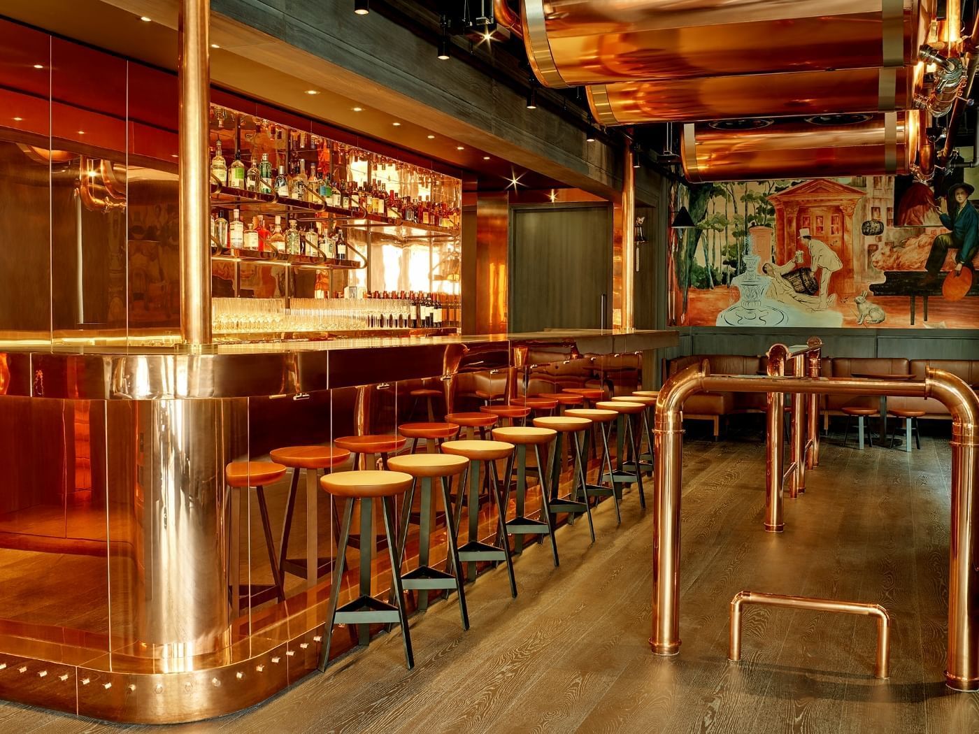 The stunning copper-clad bar at Joshua’s Tavern in The Londoner, featuring unique pipework and a historical mural