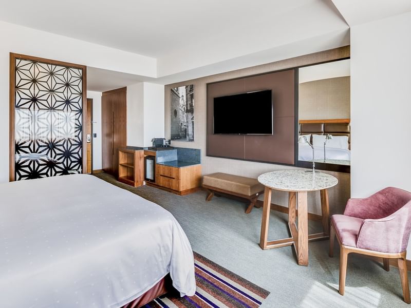 TV facing Bed and couch in Deluxe Room,1 King at Fiesta Americana Brand