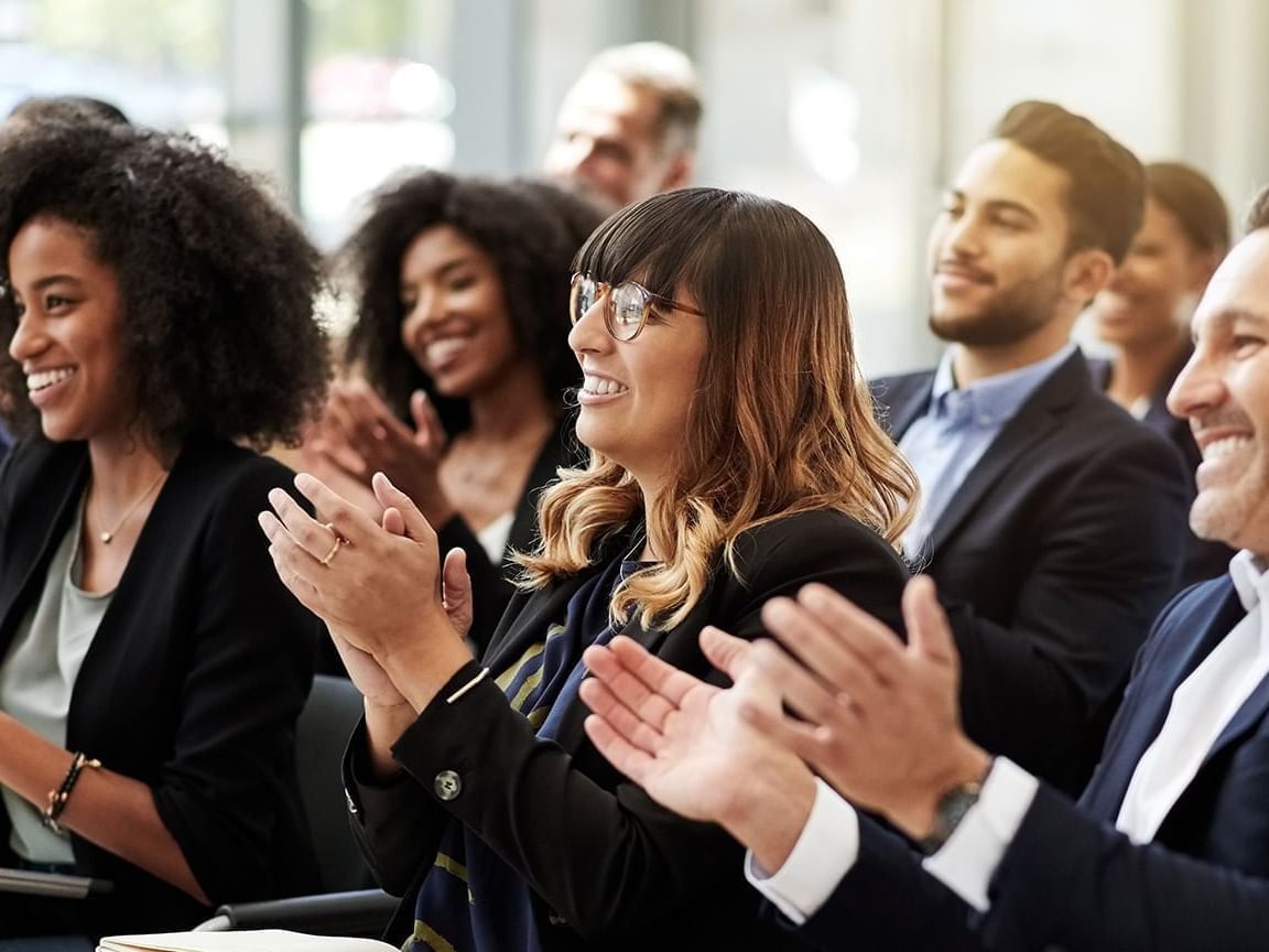 Professional audience members smiling and applauding during the IAMC International Monterrey held at One Hotels