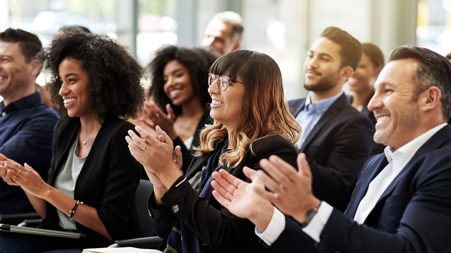 A group of individuals clapping in the conference at Fiesta Americana