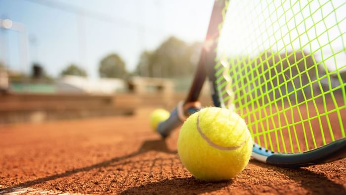 Closeup of a tennis racket & ball on Court at Originals Hotels