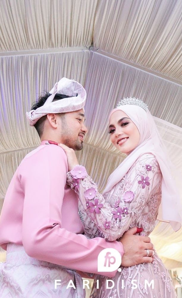Bride & groom in pink wedding attire posing for a photo at Hotel Maya Kuala Lumpur City Centre