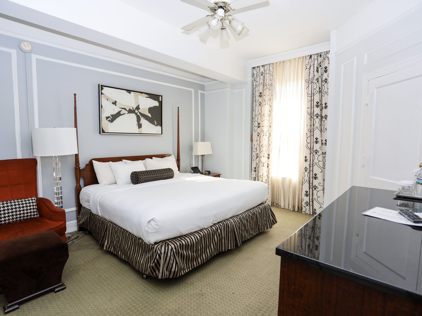 Historic Room featuring a red armchair and abstract art above the bed at Arlington Resort Hotel & Spa