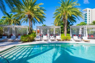 Outdoor pool area with lounge chairs and palm trees, surrounded by The Residences at Seafire