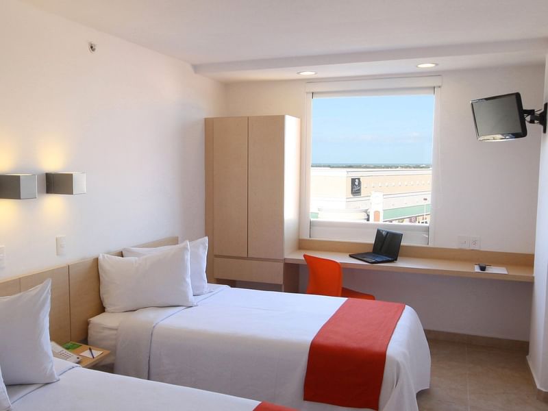 Interior de la habitación superior con dos camas individuales en One Hotels