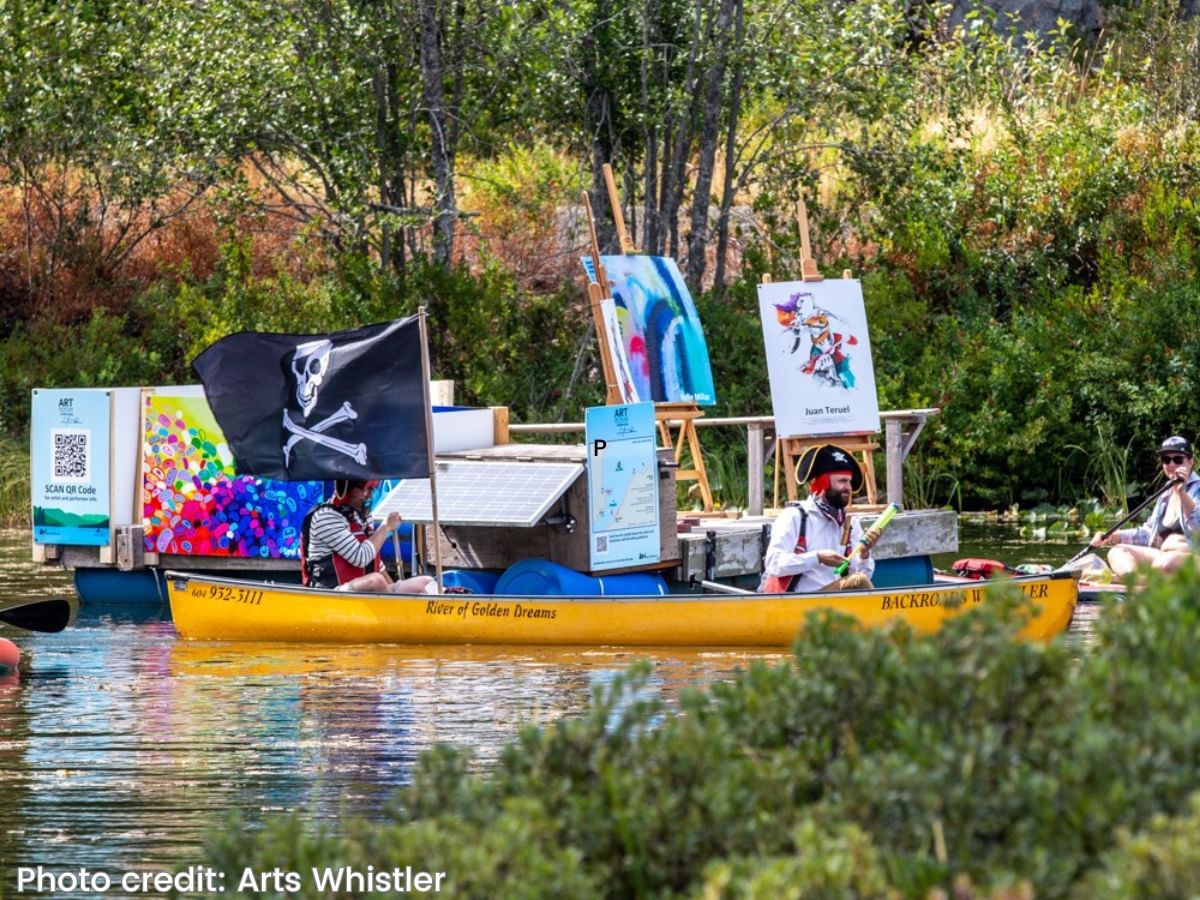 People paddling boats with arts in Alta Lake near Blackcomb Springs Suites
