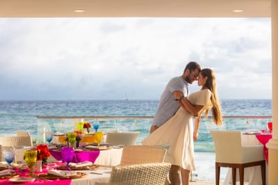 Couple embracing on a balcony by the sea at Villa Premiere Boutique Hotel & Romantic Getaway