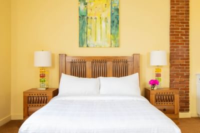 King bed, wooden bedside cupboards with lamps & yellow walls Queen Premiere Mellow at Retro Suites Hotel