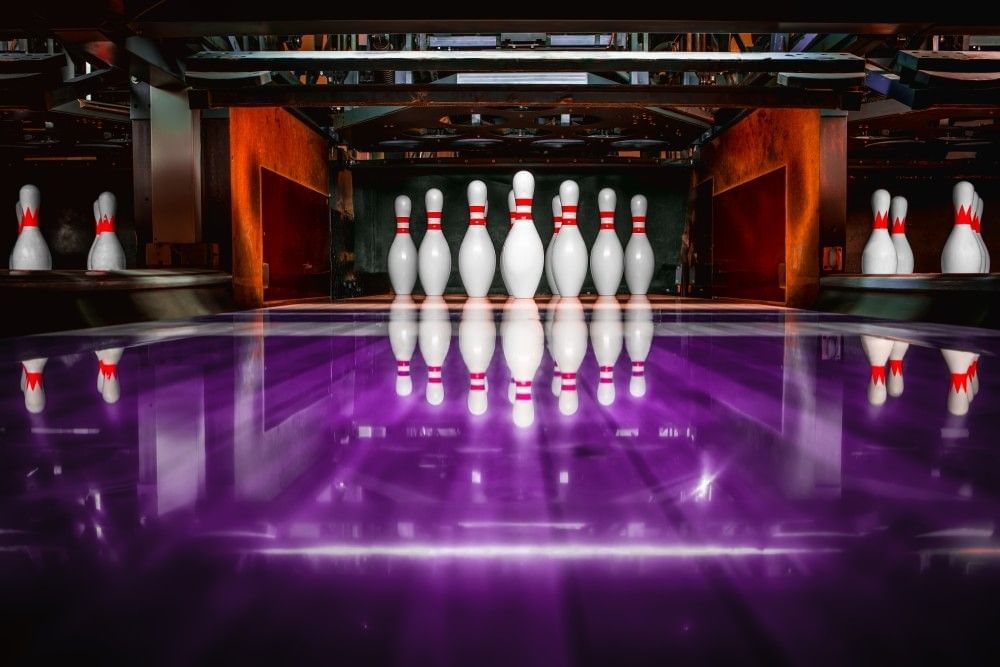 A close-up of bowling pins standing at the end of a bowling lane. 