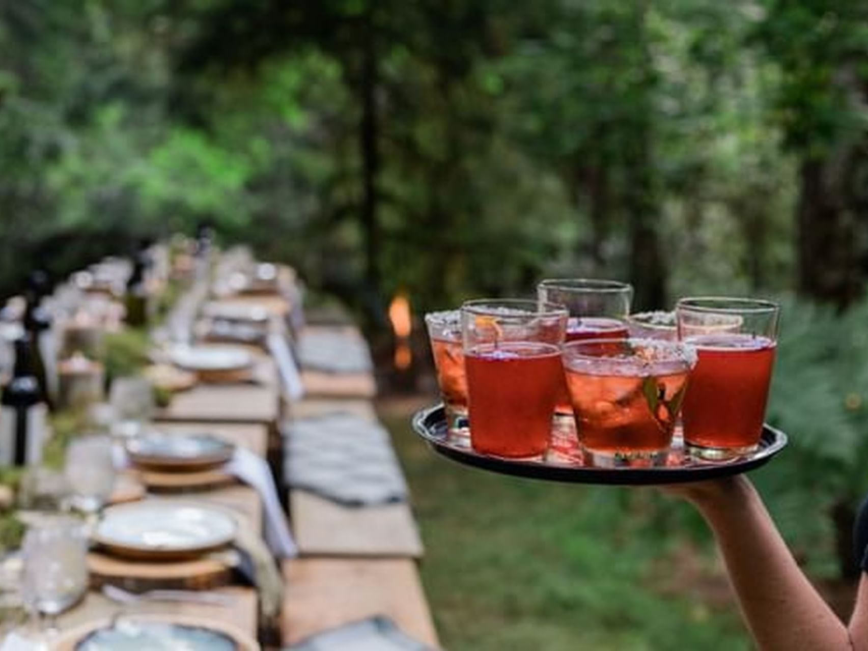 Close-up of waiter holding a tray of cocktails by an outdoor dining venue at Alderbrook Resort & Spa