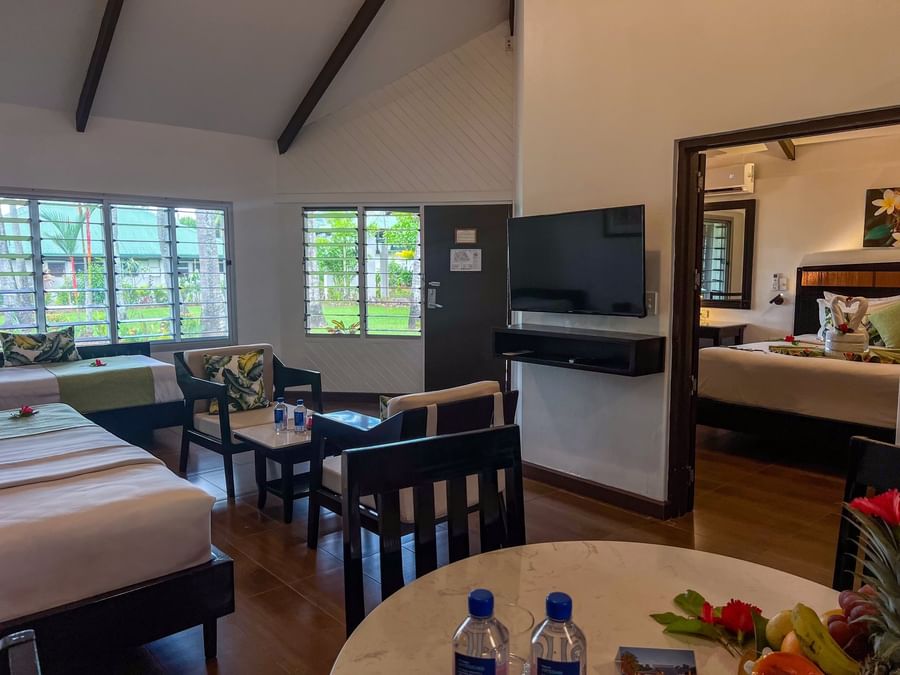 One Bedroom Villa featuring a seating area with dark wood chairs and a wall-mounted TV at TokaToka Resort Nadi Fiji