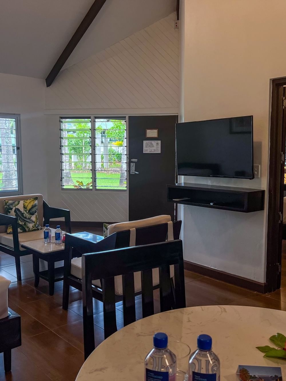 One Bedroom Villa featuring a seating area with dark wood chairs and a wall-mounted TV at TokaToka Resort Nadi Fiji
