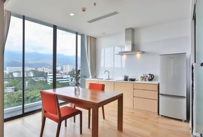 Dining table & kitchen area with pantry in a room at Eastin Hotels