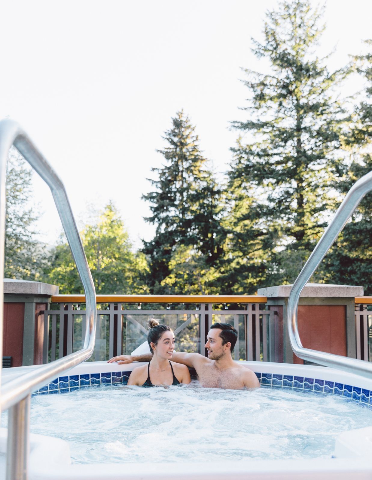 Couple lounging in the outdoor jacuzzi at Nita Lake Lodge
