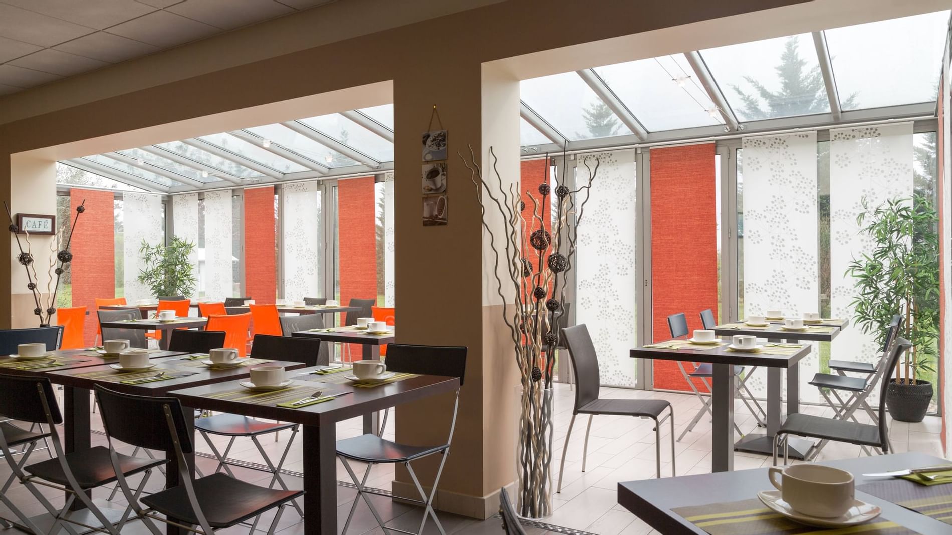 Arranged chairs & tables with tea cups at The Originals Hotels