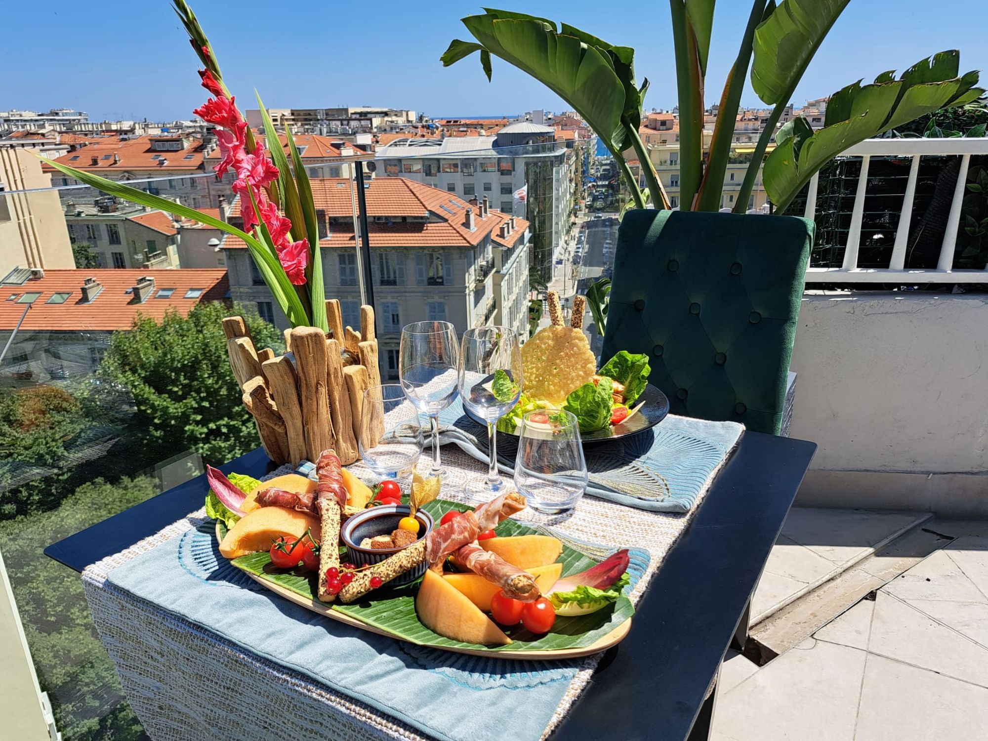 Gourmet appetizer platter served on a balcony with a skyline backdrop in The Jungle Restaurant at Splendid Hotel & Spa Nice