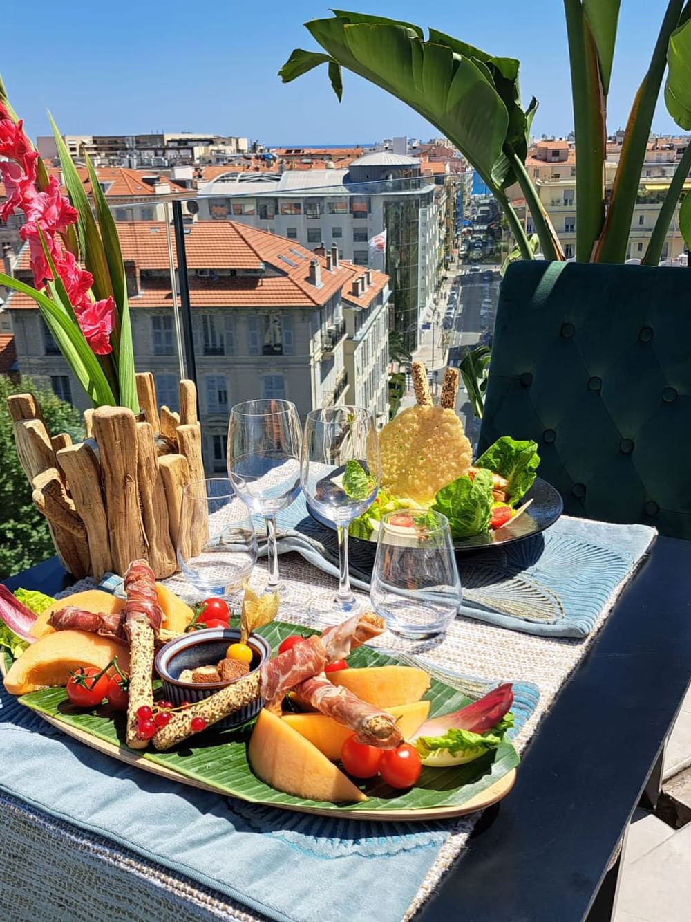 Gourmet appetizer platter served on a balcony with a skyline backdrop in The Jungle Restaurant at Splendid Hotel & Spa Nice