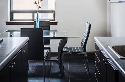Glass dining table & leather chairs at Embassy Hotel & Suites