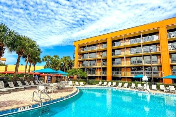The exterior of Rosen Inn at Pointe Orlando, including a shot of the pool and surrounding palm trees.