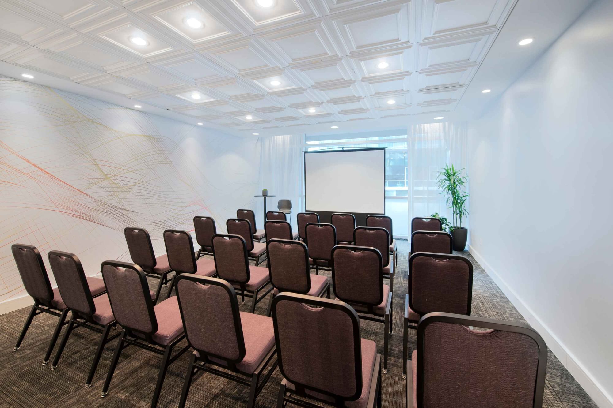 Theatre set-up with a projector screen in a meeting room at Warwick Hotels and Resorts