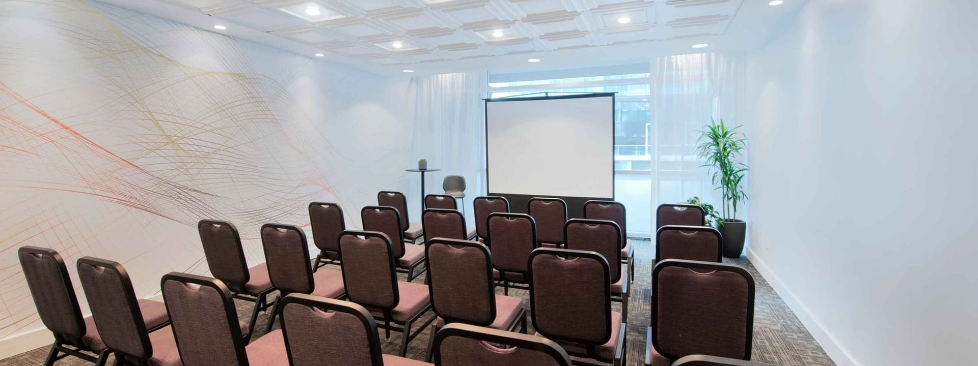 Installation théâtrale avec écran de projection dans une salle de réunion du Warwick Hotels and Resorts