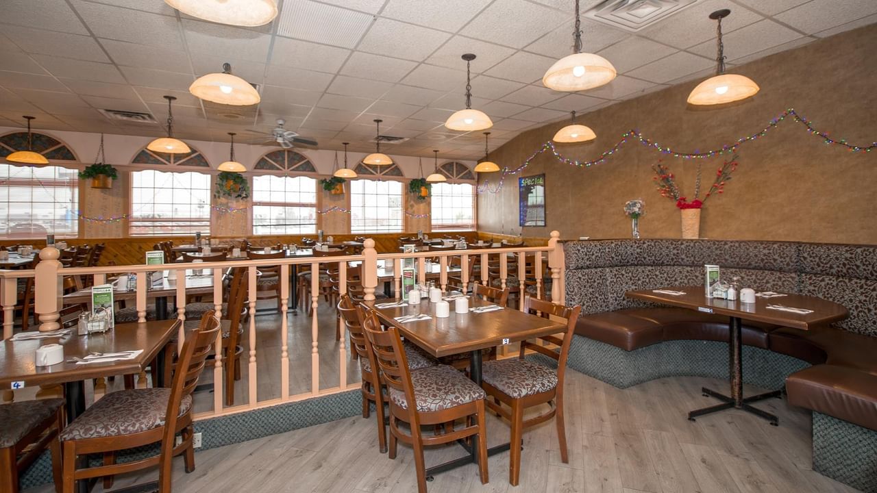 wood tables, chairs and large windows at Green Gables Restaurant & Lounge