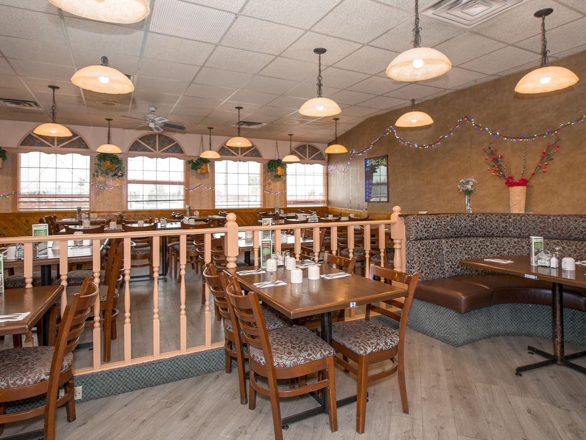 Restaurant interior with dining tables, booth seating and a bar area at Green Gables Restaurant & Lounge