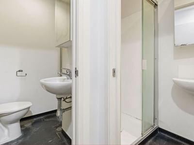Clean, modern bathroom with white fixtures and tiled floor at Student Living Auckland Beach.