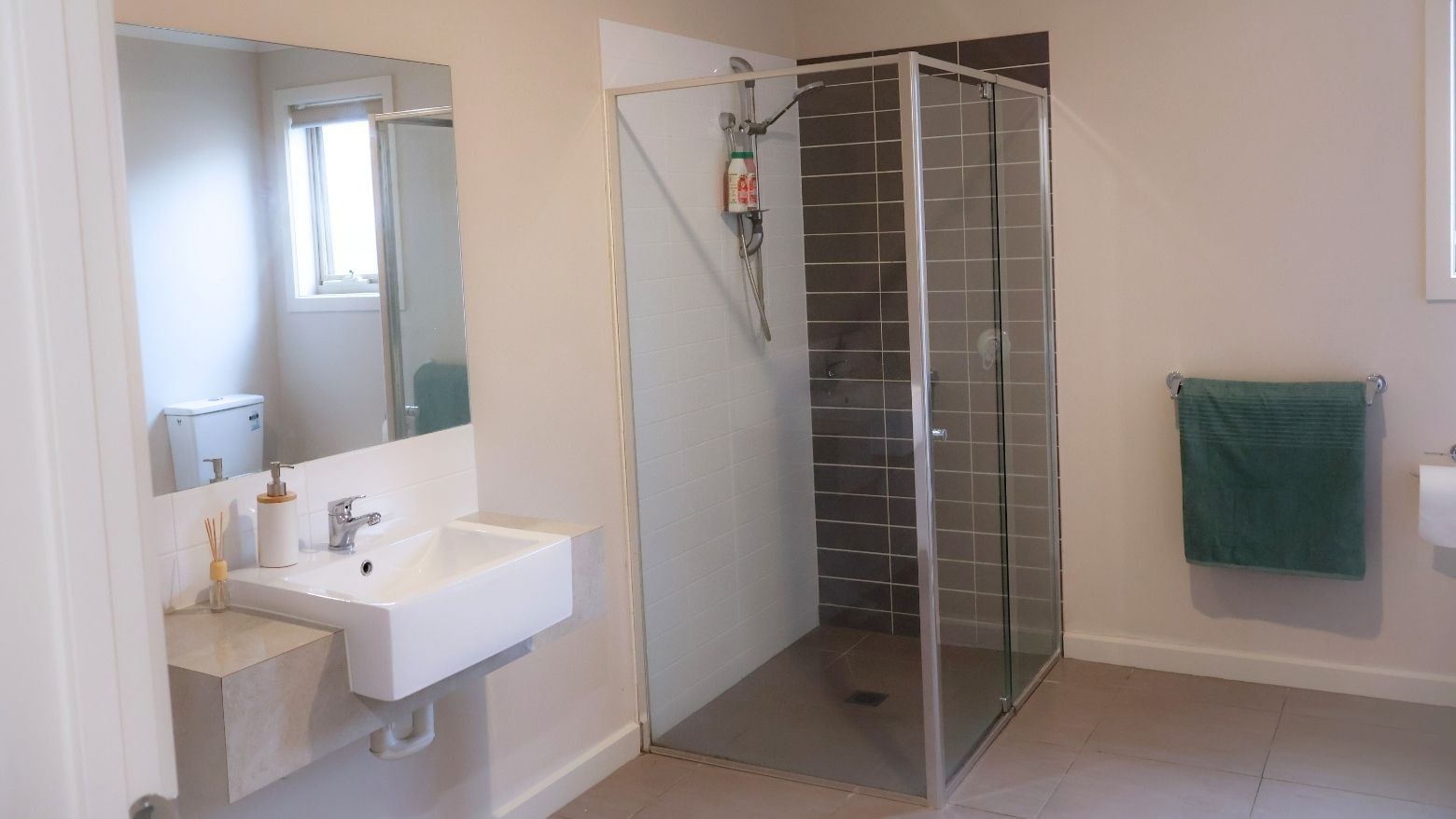 Modern bathroom with shower stall, sink, and mirror at La Trobe University Regional Housing – Melton.