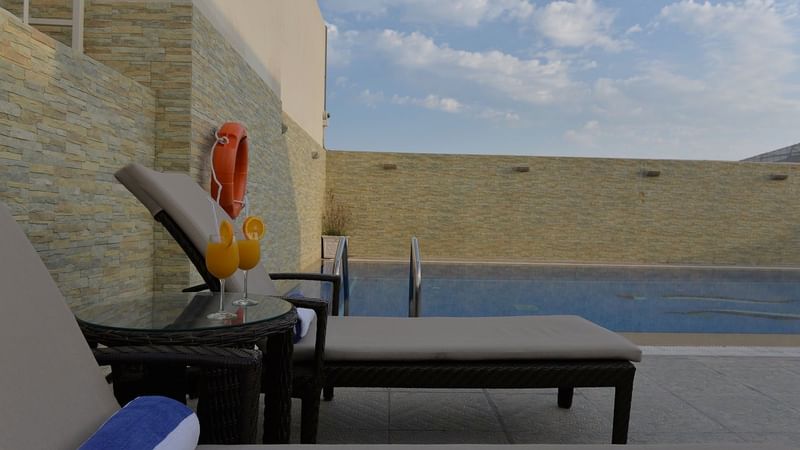 Sun loungers by the pool in Wellness & Spa at Strato Hotel by Warwick Doha