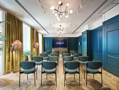 Classroom set-up with patterned wood flooring and TV in Salon 1 at Hotel Motto Vienna