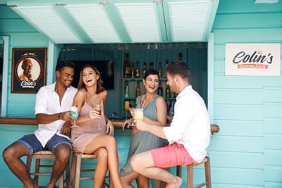 2 couples having cocktails by the Colin's Rum Shop at Sugar Bay