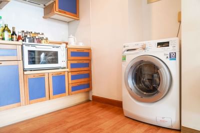 Kitchen with blue cabinets and a washer at Hanoi Daewoo Hotel