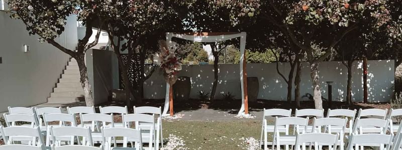 Outdoor wedding setup with white chairs at Pullman Magenta Shores
