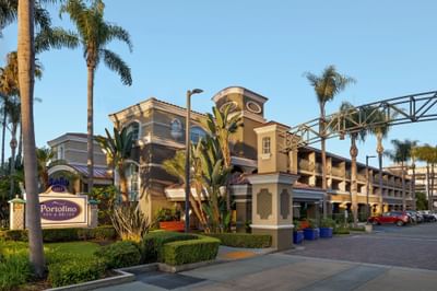 Entrance of Anaheim Portofino Inn & Suites by palm trees, featuring family suite hotel two blocks from Disneyland entrance 